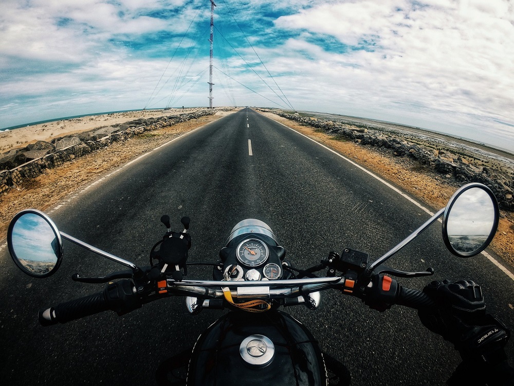 biker riding motorcycle on highway in countryside